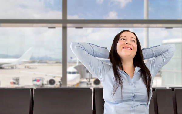 Женщина улыбается в вестибюле аэропорта — стоковое фото