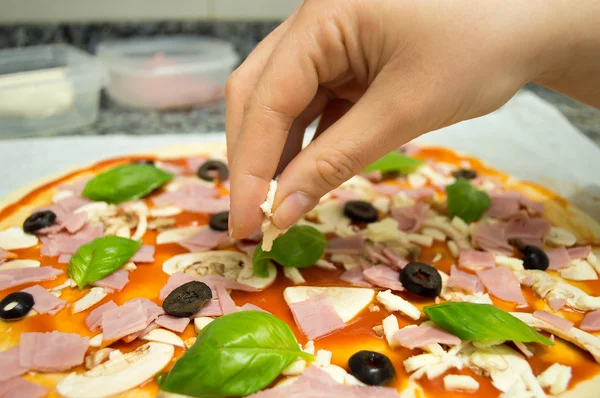 Adding mozzarella to the pizza — Stock Photo, Image