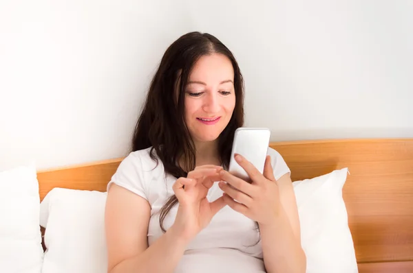 Eine Nachricht im Bett senden — Stockfoto