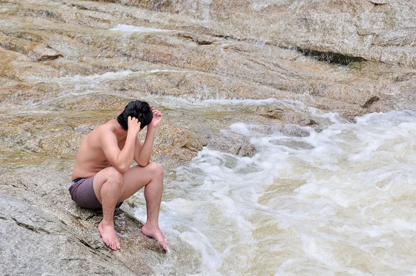 Depressiver Mann sitzt auf den Felsen — Stockfoto