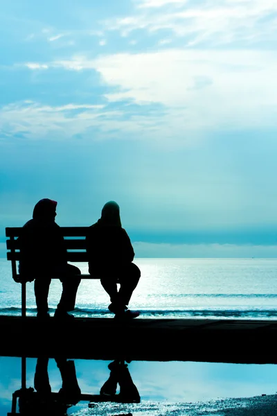 Dva přátelé sedí na dřevěné lavičce — Stock fotografie