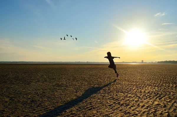 Miúdo a correr na praia ao pôr do sol — Fotografia de Stock