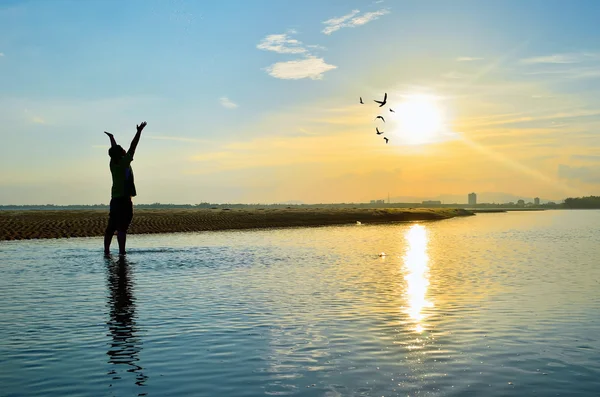 Man zijn handen verhogen in zonsondergang — Stockfoto