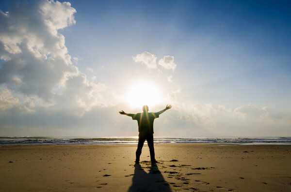 Silhouette of Man Raising His Hands or Open arms when sunrise