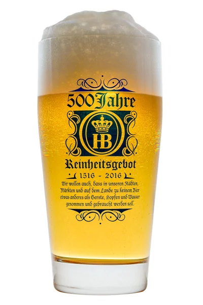 Birra bavarese fredda in vetro con schiuma schiumosa isolata retroilluminata Fotografia Stock