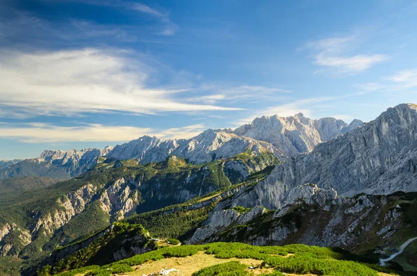 Alpen Sonnenlicht hohe Berggipfel mit grünem Tal und blauem Himmel — Stockfoto