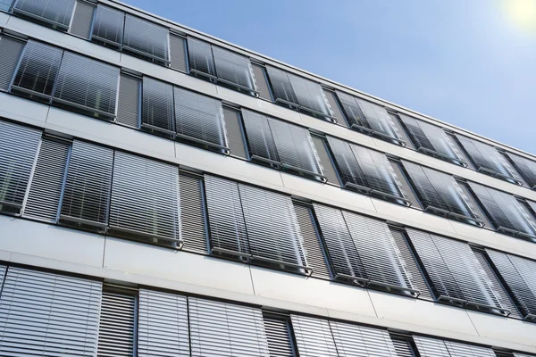 Höghus kontorsbyggnad fasad med täckt windows venetianska b Stockfoto