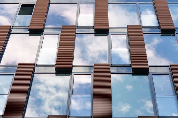 Blauwe lucht weerspiegeld in spiegel windows van moderne kantoorgebouw — Stockfoto