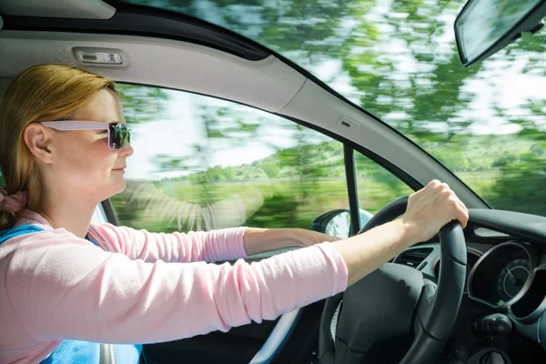 Smiling beautiful woman in sunglass driving car at high speed — Stock Photo, Image