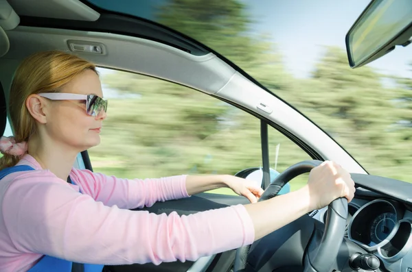 Pretty woman in sunglasses driving fast car — Stock Photo, Image