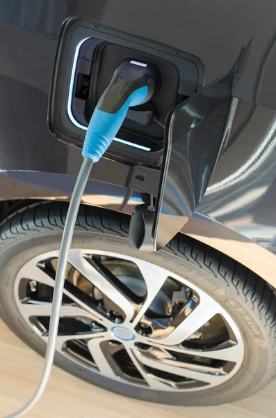 Modern electric car plugged in to power supply charging station — Stock Photo, Image