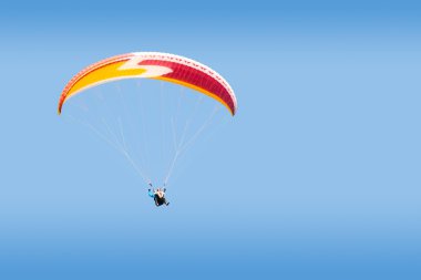 Tandem paraglider free gliding in deep blue sky clipart