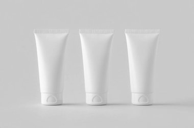 Gri arkaplanda beyaz plastik krem tüp..