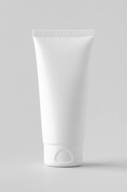 Gri arkaplanda beyaz plastik krem tüp..