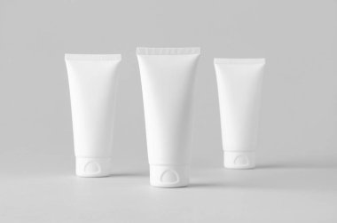 Gri arkaplanda beyaz plastik krem tüp..