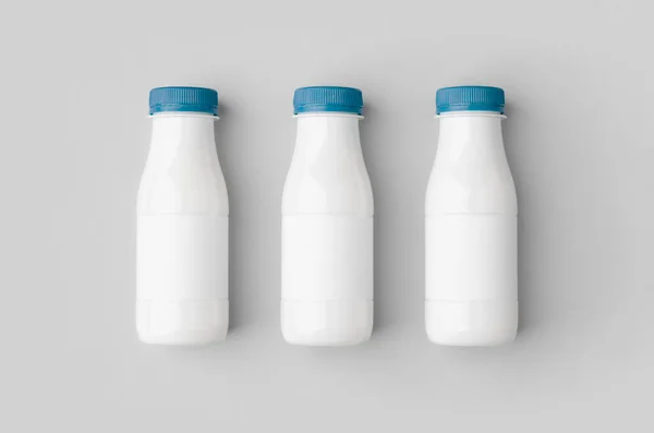 白いプラスチックヨーグルトやミルクボトルのモックアップとともに空白のラベル — ストック写真