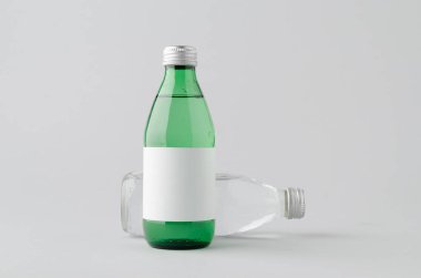 Temiz ve yeşil cam su şişesi. Tarafsız arkaplanda boş etiket var.