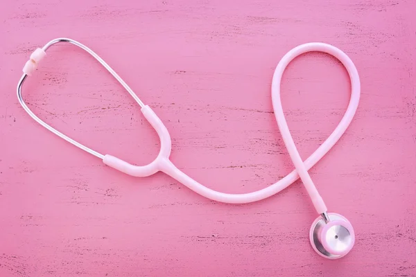 Pink Stethoscope on wood table. — Stock Photo, Image