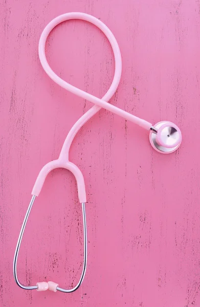Pink Stethoscope on wood table. — Stock Photo, Image