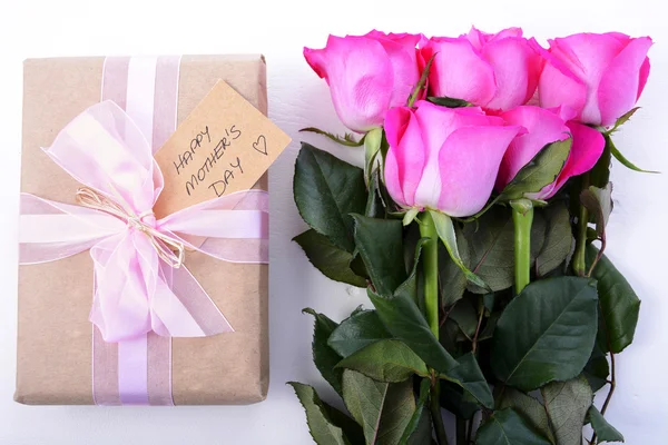 Brown Paper gift and pink roses. — Stock Photo, Image