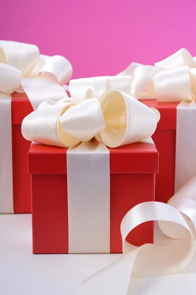 Red and white gifts on pink background. — Stock Photo, Image