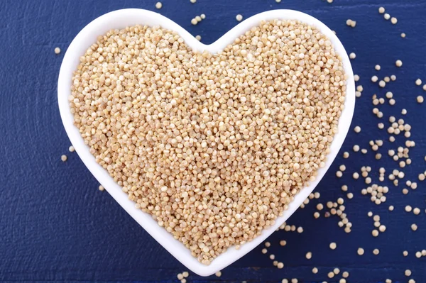 White grain quinoa on blue wood background. — Stock Fotó