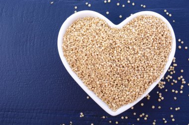 White grain quinoa on blue wood background. 