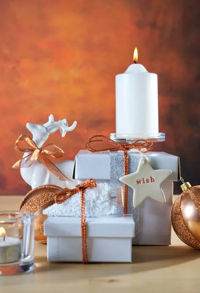 Cadeaux de Noël en cuivre et blanc empilés sur une table de fête. — Photo