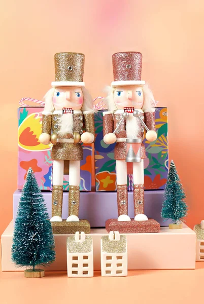 Kerst notenkraker ornamenten en geschenken tegen een moderne koraal achtergrond. — Stockfoto