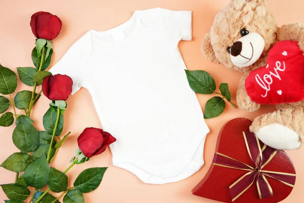 San Valentín ropa de bebé flatlay vista superior en la mesa amarilla. Prepárate.. —  Fotos de Stock