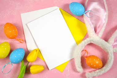 Paskalya ürünü. Tavşan kulaklı ve pembe arka planda paskalya yumurtaları.