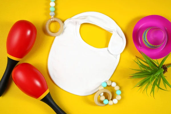 Cinco de Mayo bebê babador flatlay em um fundo de mesa amarelo festivo — Fotografia de Stock