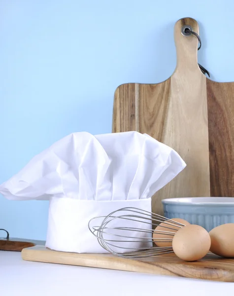 Modern blue and white kitchen with chefs hat and utensils. — Stock Photo, Image