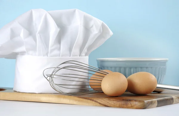 Modern blue and white kitchen with chefs hat and utensils. — Stock Photo, Image