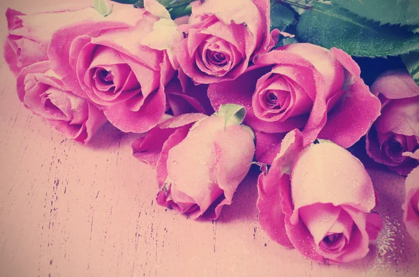 Rosa rosor på rosa trä bakgrund närbild. — Stockfoto
