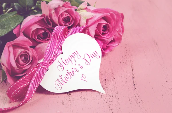 Mothers Day gift of fresh pink roses on a pink distressed wood background — Stock Photo, Image