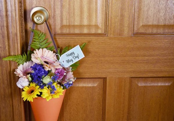 Ευτυχής ημέρα Μαΐου δώρο των λουλουδιών την πόρτα. — Φωτογραφία Αρχείου