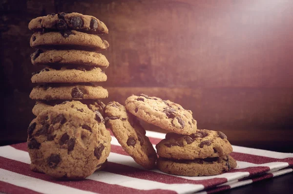 Galletas de chispas de chocolate sobre fondo de madera oscura . —  Fotos de Stock