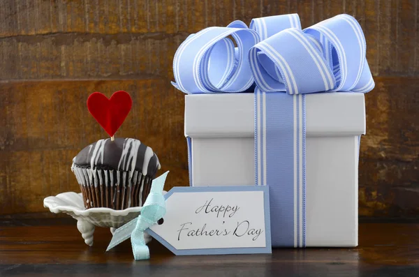 Conceito de pais felizes com presente azul e branco e cupcake . — Fotografia de Stock