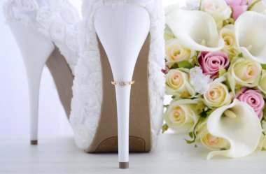 Wedding ring on beautiful white stiletto shoe heel.  clipart