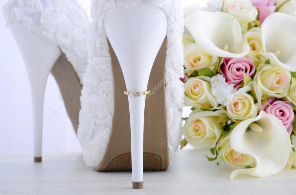 Wedding ring on beautiful white stiletto shoe heel. 