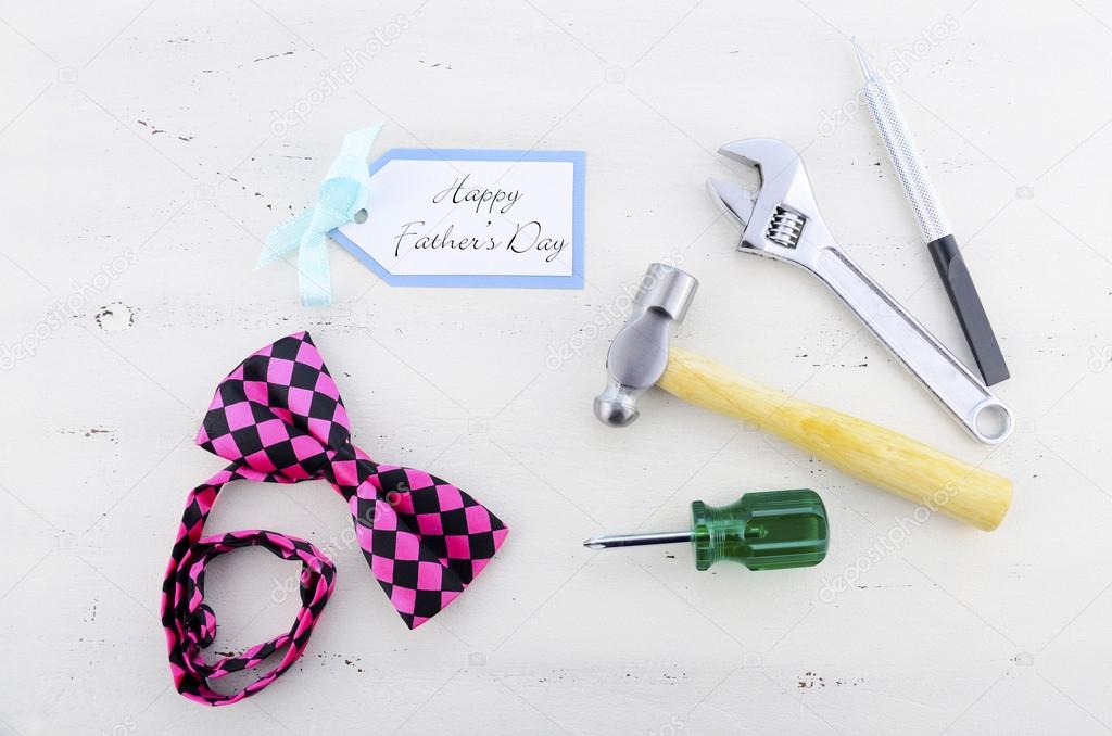 Happy Fathers Day concept with mens tools and pink bow tie. 