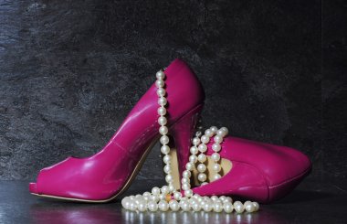 Ladies pink high heels with long strand of white pearls 