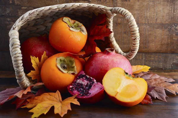 Korb mit frischen Kaki und Granatäpfeln — Stockfoto