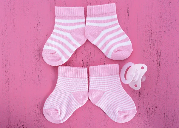 Its a Girl Baby Shower or Nursery concept with socks on pink woo — Stock Photo, Image