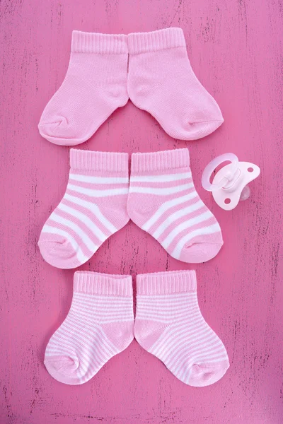 Its a Girl Baby Shower or Nursery concept with socks on pink woo — Stok fotoğraf