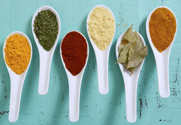 Especiarias de cozinha coloridas na mesa de madeira — Fotografia de Stock