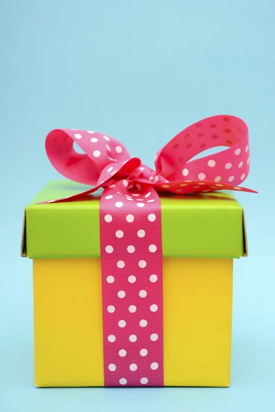 Caixa de presente de cor brilhante no fundo rosa e azul . — Fotografia de Stock