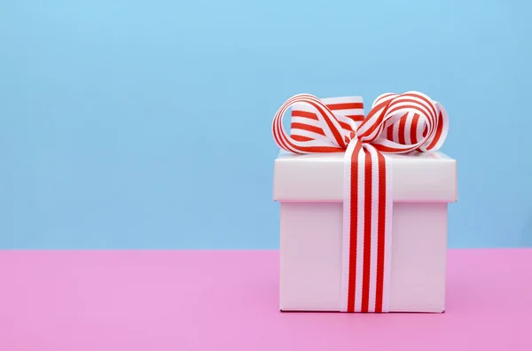 Heldere kleur Gift Box op roze en blauwe achtergrond. — Stockfoto