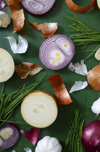 Onions, chives and garlic scattered on wood table — Stock Photo, Image